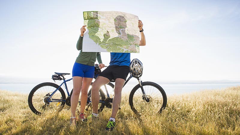Two bicyclists looking at a map